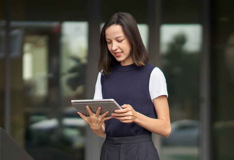 Microsoft product photograph of a person reading on a tablet outside an office